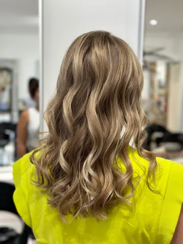 Balayage blond beige sur cheveux longs ondulés