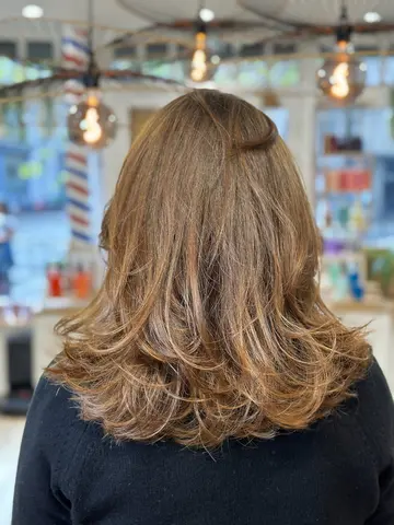 Coupe mi-longue effilée et brushing volume, châtain doré