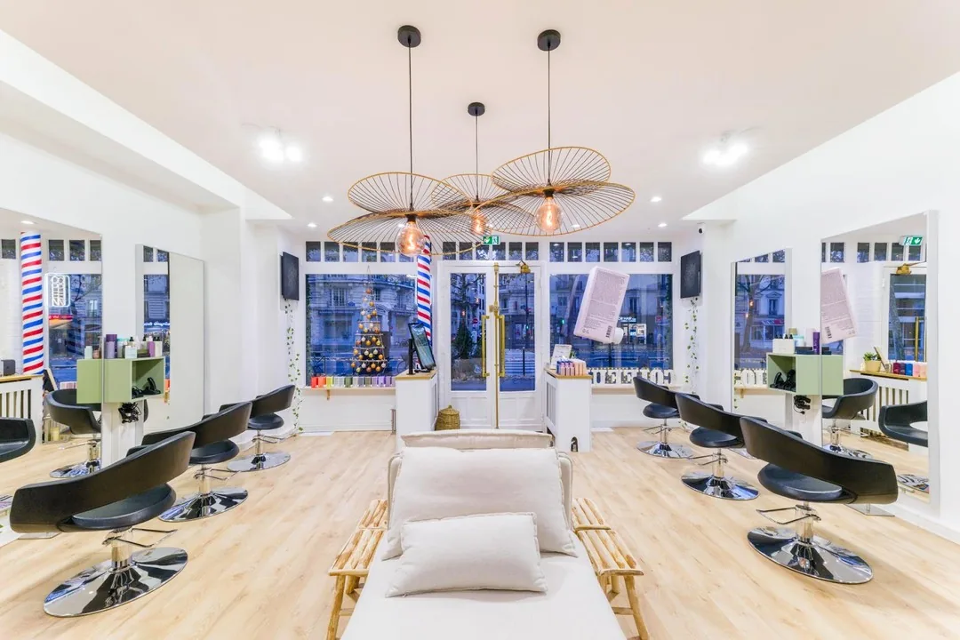 Intérieur du salon XOXO COIFFURE, à deux pas du métro Vavin — fauteuils et lumière naturelle
